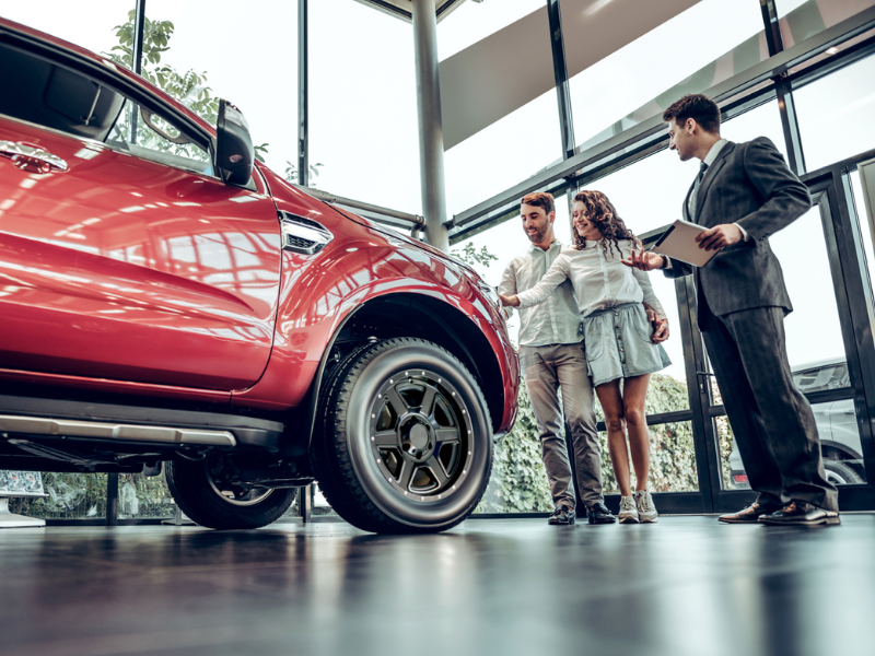 People standing with Salesmen looking at a truck  on display